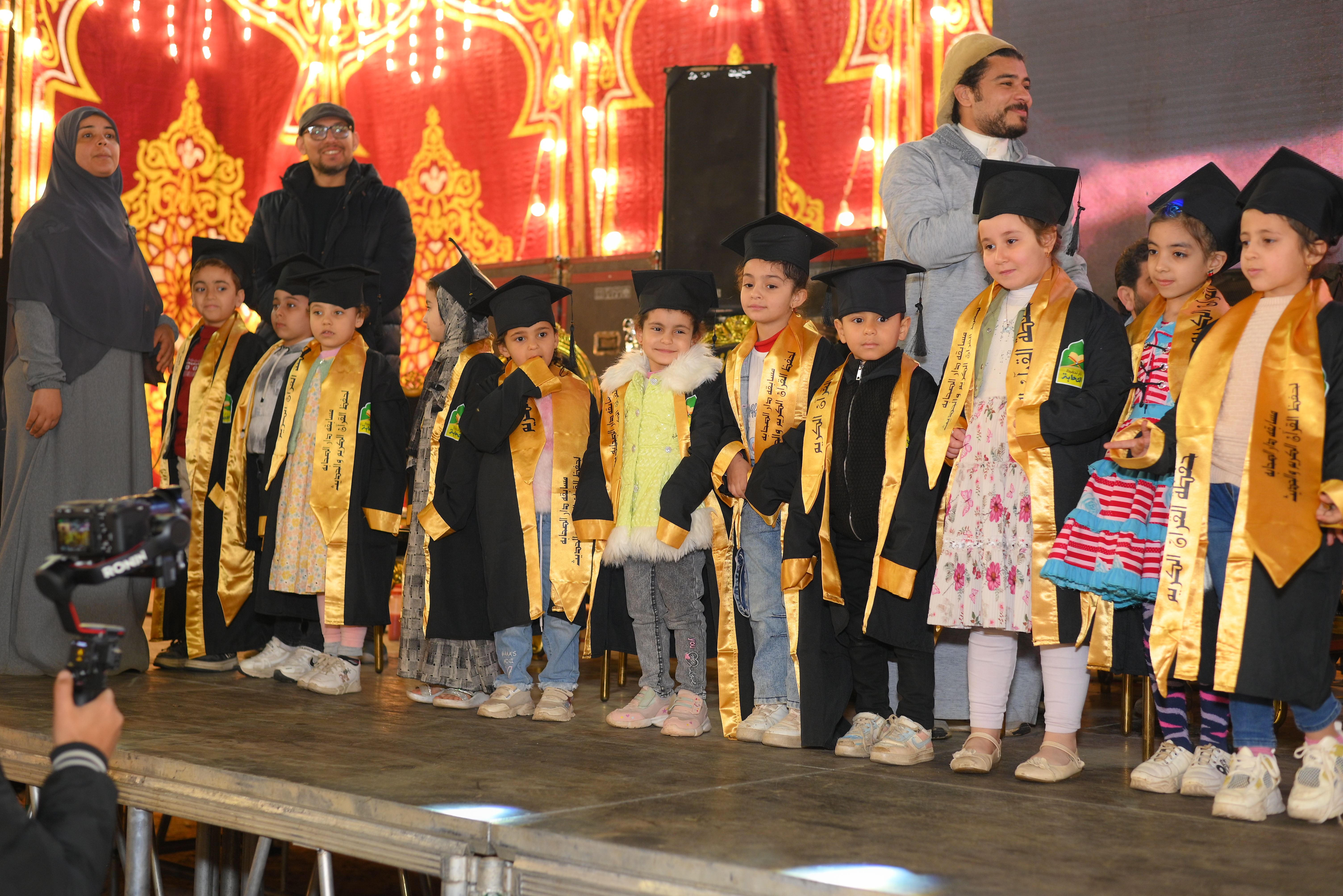 Kids in graduation gowns on stage