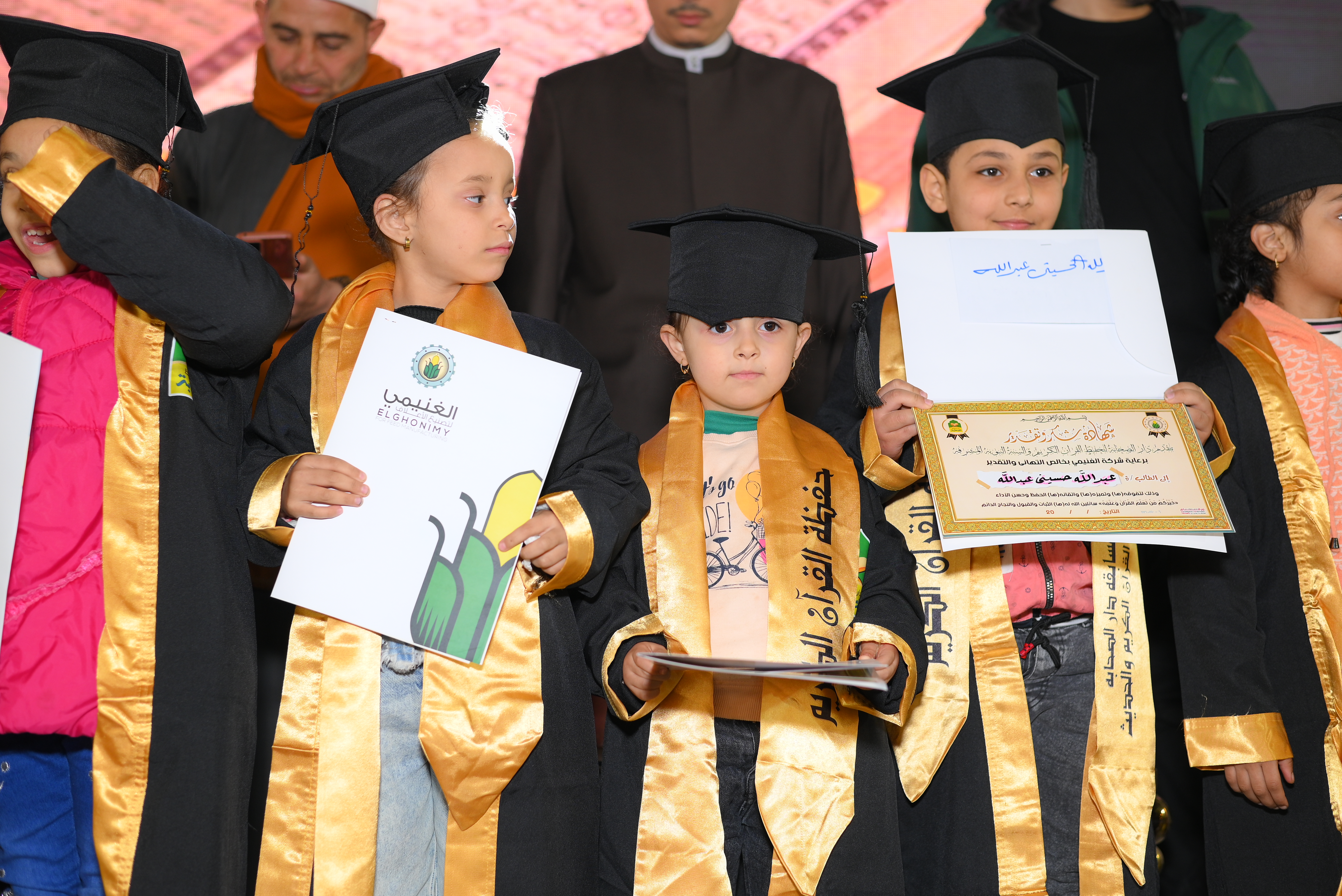 Children holding competition certificates and gifts